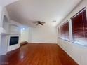 Spacious living room with fireplace, ceiling fan, hardwood floors and large windows at 9299 Adamshurst Ave, Las Vegas, NV 89148