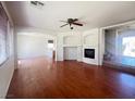 Spacious living room with hardwood floors, fireplace, ceiling fan and staircase at 9299 Adamshurst Ave, Las Vegas, NV 89148