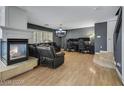 Cozy living room with a modern fireplace, hardwood floors, and comfortable seating at 10218 Maltese Cross Ct, Las Vegas, NV 89183