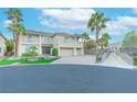 Beautiful two-story home featuring lush landscaping, a paver driveway, and a three-car garage at 11002 Inverlochy Ct, Las Vegas, NV 89141