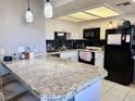 Well-lit kitchen boasts granite countertops, white cabinets, and a stylish black tile backsplash at 1105 Sulphur Springs Ln # 202, Las Vegas, NV 89128