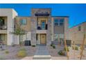 Modern townhome showcasing stone facade, covered balcony, and xeriscaped front yard at 1135 Tektite Ave, Henderson, NV 89011