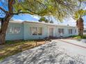 Inviting one-story home featuring a light blue exterior, white shutters, and a spacious front yard at 1139 5Th Pl, Las Vegas, NV 89104
