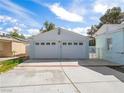 Detached two-car garage with white doors, surrounded by a spacious concrete driveway and manicured greenery at 1139 5Th Pl, Las Vegas, NV 89104