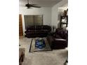 Living room with large window, carpet, ceiling fan, and leather sofas at 1407 Santa Margarita St # A, Las Vegas, NV 89146
