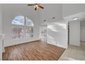 Bright living room featuring wood floors, high ceilings, and a large arched window at 1821 Cedar Bluffs Way, Las Vegas, NV 89128
