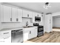 Contemporary kitchen featuring white cabinets, quartz countertops, and modern stainless steel appliances at 1940 Walker St, Las Vegas, NV 89106