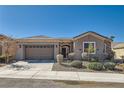 Charming single-story home with a two-car garage, landscaped front yard, and stone accent entry at 2345 Gondi Castle Ave, Henderson, NV 89044