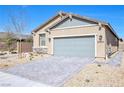 Charming single-story home with a desert-landscaped front yard and gray brick driveway under a clear blue sky at 2404 Elmont Ave, North Las Vegas, NV 89086