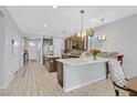 Open-concept kitchen boasting stainless steel appliances, an island, and modern pendant lighting at 2587 Tolmezzo St, Henderson, NV 89044