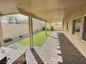 Covered backyard patio features a brick surface and low maintenance artificial turf at 3581 Rio Paloma Ct, North Las Vegas, NV 89031