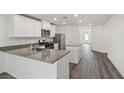 Modern kitchen with stainless steel appliances, center island, and stylish gray countertops and wood floors at 4224 Golden Sol St, North Las Vegas, NV 89032