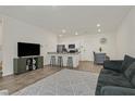 Open-concept living space features wood flooring, a spacious seating area, an eat-in kitchen with white cabinets, and recessed lighting at 527 Clearsable Ave, Henderson, NV 89044