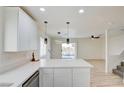 Well-lit kitchen boasting modern pendant lights, white cabinets, stainless appliances and spacious countertops at 5720 Ritter Ln, Las Vegas, NV 89118