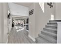 Bright hallway with staircase, grey flooring, and access to the open-concept living area at 625 Honesty Ct, Henderson, NV 89011