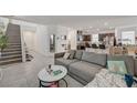 Open living area with tile floors, stairs, and a comfortable gray sofa at 6747 Marjoram St, Las Vegas, NV 89166