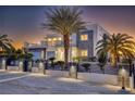 Beautiful modern home with desert landscaping, a gated entrance, and stone accents at twilight at 675 Benedict Dr, Las Vegas, NV 89110
