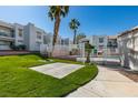 Well-maintained community grounds and pool area featuring mature palm trees and lush green grass at 6800 E Lake Mead Blvd # 1034, Las Vegas, NV 89156