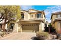 Charming two-story home featuring a brick driveway, neutral exterior, and lush landscaping at 8216 Chimney Bluffs St, North Las Vegas, NV 89085