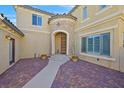 Charming home entrance featuring a rounded stone entryway and lovely brick paved courtyard at 10001 Blairwood Ct, Las Vegas, NV 89178