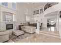 The grand living room has soaring ceilings, a fireplace, and an open floor plan at 1436 Via Merano St, Henderson, NV 89052