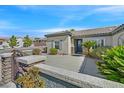 Inviting front entrance features a secure stone wall, gate, and beautiful landscaping at 2054 Wildwood Lake St, Henderson, NV 89052