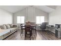 Bright living area featuring wood floors, comfortable seating, dining area, and a dedicated workspace at 2108 Running River Rd, Henderson, NV 89074