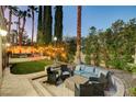 Beautiful backyard patio with a seating area, lush landscaping, and a tranquil water feature at 2508 Monarch Bay Dr, Las Vegas, NV 89128