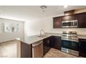 Well-equipped kitchen with granite countertops, stainless steel appliances, and dark wood cabinets at 2813 Riverside Gold Ct, North Las Vegas, NV 89086