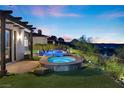 Relaxing backyard retreat features an inground pool, raised jacuzzi, stone accents and desert landscaping at 3 Rue Allard Way, Henderson, NV 89011