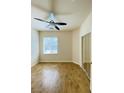 Bright bedroom features wood-look flooring, a large window, and a mirrored closet at 3661 Hammock St, Las Vegas, NV 89147