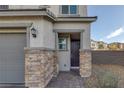 Exterior entryway featuring stone pillar accents, a dark front door, and desert landscaping at 3771 Bright Aquarius Ln, Henderson, NV 89052