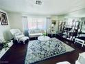 Living room view with hardwood floors, vintage furniture, large area rug, and bright natural light at 3856 Commanche Ave, Las Vegas, NV 89121