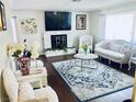 Bright living room features a white brick fireplace and mantel with hardwood floors and elegant furniture at 3856 Commanche Ave, Las Vegas, NV 89121