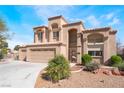 Charming two-story home boasts a three-car garage and a well-manicured front yard with desert landscaping at 4708 Royal Sunset Ct, Las Vegas, NV 89130