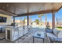 Outdoor kitchen and seating with pool views, bar, a ceiling, and lounge area for entertaining at 720 Camino La Paz, Henderson, NV 89012