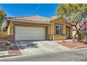 Attractive single-story home featuring desert landscaping, a two-car garage, and a tiled roof at 813 Royal Elm Ln, Las Vegas, NV 89144