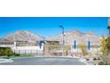 Community entrance featuring a landscaped median and backdrop of picturesque mountain views at 828 Parker Mesa St, Las Vegas, NV 89138