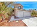 Inviting two-story home with a two-car garage, lush landscaping, and a welcoming walkway to the entrance at 9505 Belgate Ct, Las Vegas, NV 89129