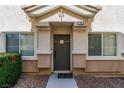 Inviting front entrance to the townhome featuring neutral colors, manicured bushes, and decorative gravel at 10107 Sunset Palisades Way # 103, Las Vegas, NV 89183
