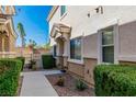 Front yard of the home with a stone pathway, manicured bushes, and desert landscaping at 10107 Sunset Palisades Way # 103, Las Vegas, NV 89183