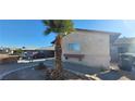 Tan single-story home featuring a front yard palm tree and desert landscaping at 1301 Madison Ave, Las Vegas, NV 89106