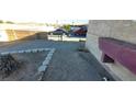 Side yard featuring dirt landscaping and side of home with textured stucco exterior at 1301 Madison Ave, Las Vegas, NV 89106