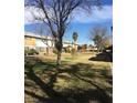 This exterior view showcases the front of the townhouses with a sidewalk and tree at 146 Greenbriar Townhouse Way, Las Vegas, NV 89121