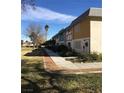 This exterior view showcases the front of the townhouses with a sidewalk and tree at 146 Greenbriar Townhouse Way, Las Vegas, NV 89121