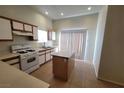 Bright kitchen featuring an island, tan tile flooring, plenty of cabinets, and a sliding glass door at 2100 Fred Brown Dr, Las Vegas, NV 89106