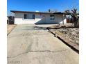 Front exterior showing the home with a driveway, white facade, and manicured front yard at 2564 San Marcos St, Las Vegas, NV 89115