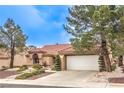 Charming single-story home featuring a desert landscaped front yard, mature trees, and a two-car garage at 2608 Golfside Dr, Las Vegas, NV 89134