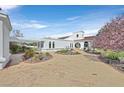 Beautiful white home with a terracotta roof, brick driveway, and meticulously landscaped garden at 3938 E Russell Rd, Las Vegas, NV 89120