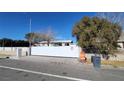 Exterior view of a single story home featuring a long, white security gate at 4928 E Monroe Ave, Las Vegas, NV 89110